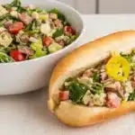 Fresh chopped Italian sub salad in a white bowl with hoagie roll